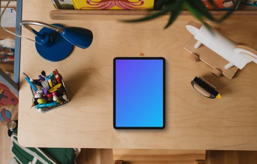 Tablet mockup on a child's desk with toys