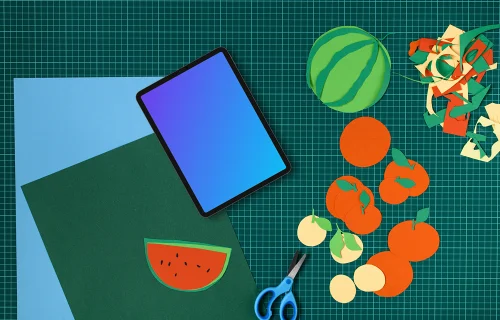 Tablet mockup on a colorful craft table with cut-out fruits