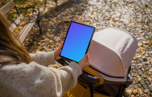 Manos de mujer sosteniendo un iPad Air en otoño mockup