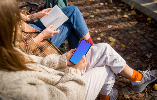 Woman holding a Google Pixel 6 in autumn park mockup