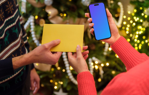 Mujer sosteniendo un teléfono y una tarjeta regalo mockup