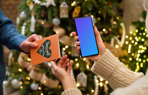 Mujer sosteniendo un teléfono mockup mientras recibe una tarjeta regalo