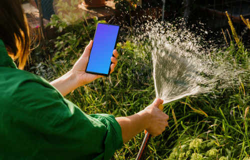 Woman holding a phone while watering grass mockup