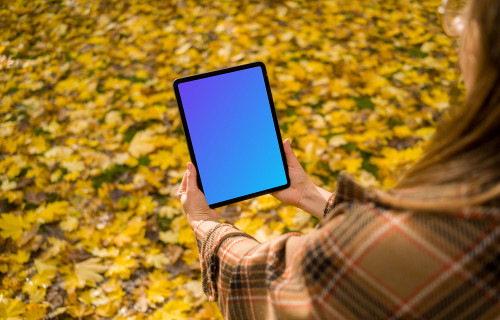 Mujer con un iPad Air en otoño mockup