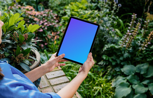 Woman holding an iPad Air mockup in garden 