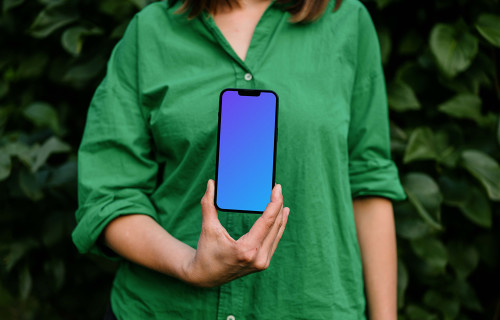 Woman holding an iPhone 13 mockup in green theme