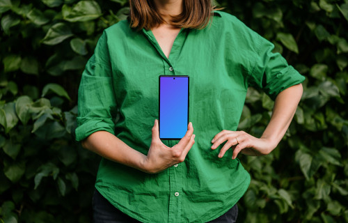 Woman in green environment holding a phone mockup 