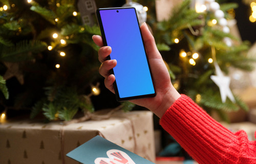 Woman in red sweater holding smartphone and gift card