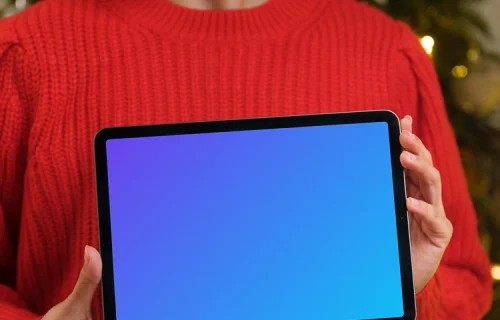 Mujer con jersey rojo sosteniendo una tableta mockup