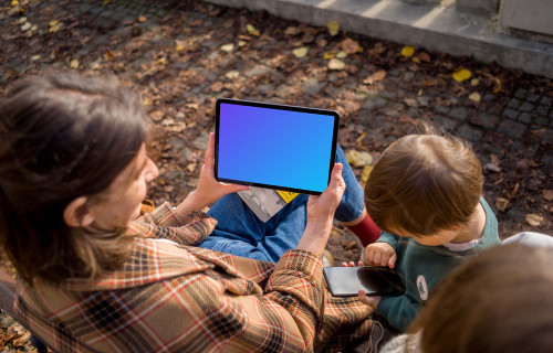 Mujer cerca de niños sosteniendo un iPad Air mockup