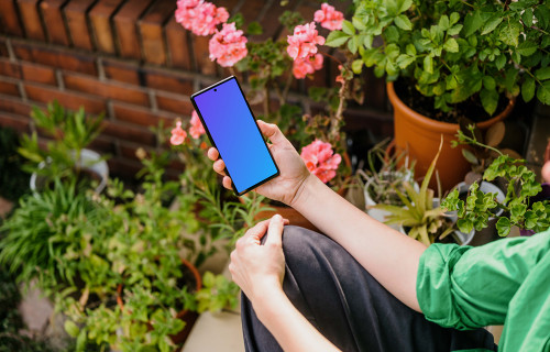 Woman sitting in a garden and holding a Google Pixel mockup