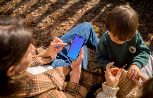 Woman typing on an iPhone 14 Pro next to the kid mockup