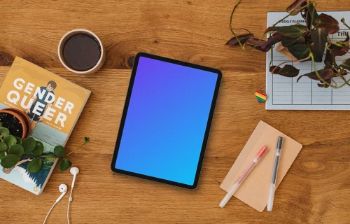 Wooden table with a tablet mockup and a pride pin