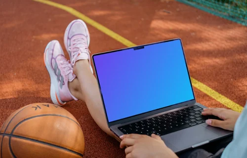 Basketball player checking on laptop mockup