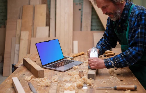 Carpenter standing next to the MacBook Pro mockup