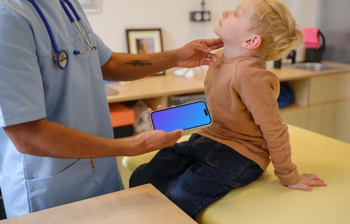 Doctor holding an iPhone mockup next to the child