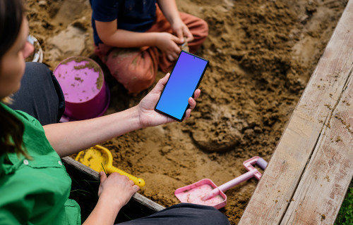 Female holding a Google Pixel in sandpit mockup