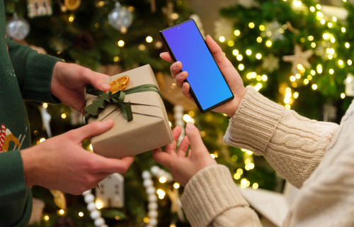 Female holding a smartphone mockup in Christmas theme