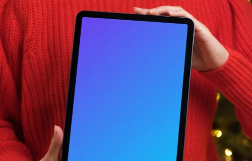 Female in red sweater holding an iPad Air mockup