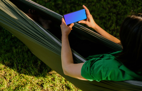 Female laying in a hammock while holding a Google Pixel 6 mockup