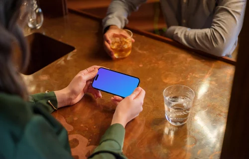 Female with iPhone mockup in her hands in the lounge setting