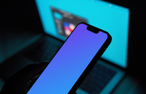Hand holding an iPhone 13 mockup