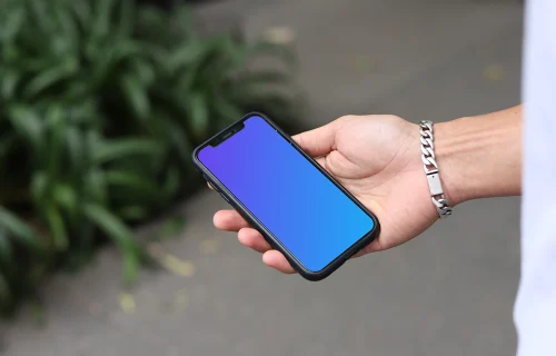 Hand with a bracelet holding an iPhone mockup