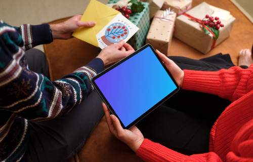 Holding iPad mockup and unpacking Christmas presents