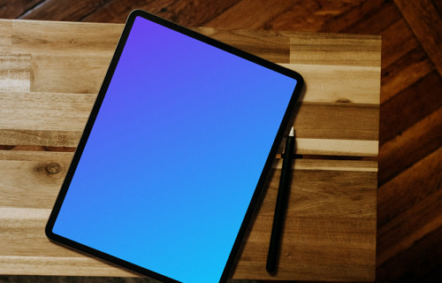 iPad mockup with pen on wooden desk