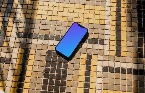 iPhone 13 mockup on a colorful garden paving