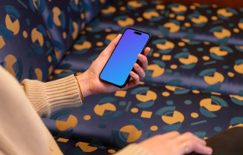 iPhone mockup held by woman’s hand in the lounge 