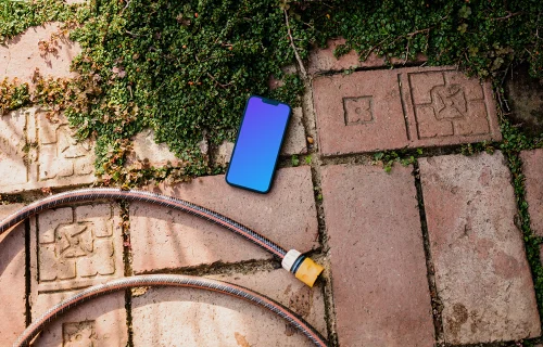 iPhone mockup on a garden paving with plants