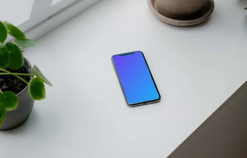 iPhone XS mockup on a window sill with plants