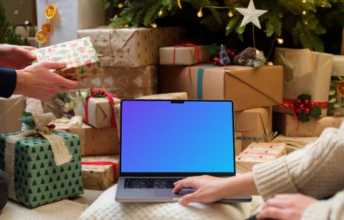 Laptop mockup surrounded by Christmas gifts