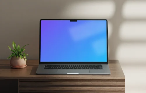 MacBook Air mockup on a wooden desk with a potted plant