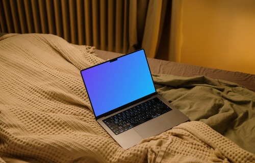 MacBook mockup on bed sheets