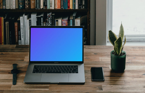 MacBook Pro mockup beside a smartphone and potted plant