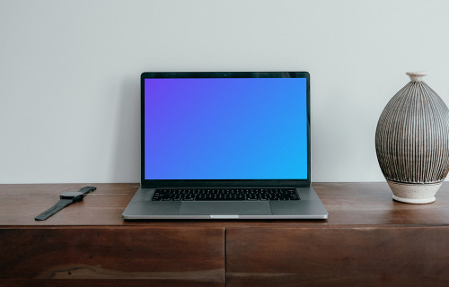 MacBook Pro mockup placed next to a vase and a knife