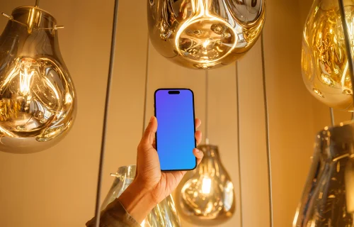 Male hand holding a iPhone mockup in the lounge