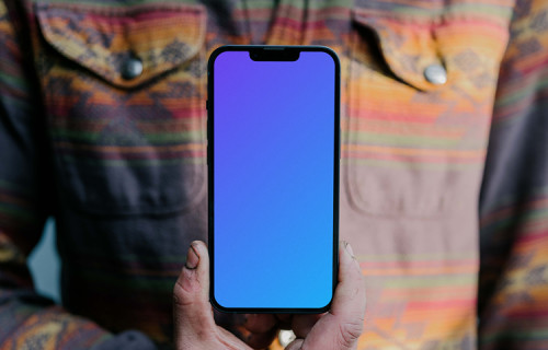 Man holding an iPhone 13 Pro mockup to his chest