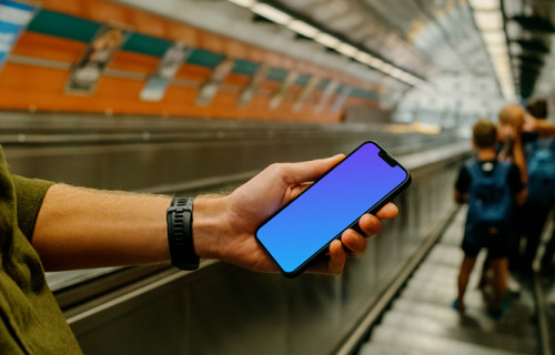 Man holding iPhone 13 mockup in subway