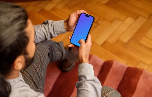 Man typing on a iPhone 14 Pro mockup in the office