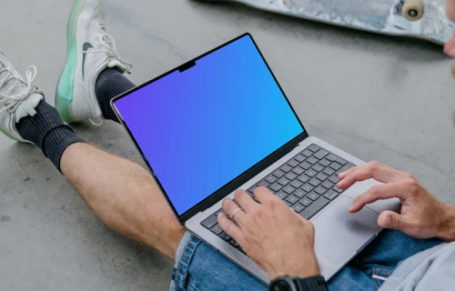 Man typing on a MacBook Pro 14 mockup with skateboard