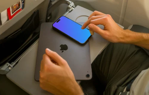 Man using iPhone 14 Pro mockup while sitting in airplane