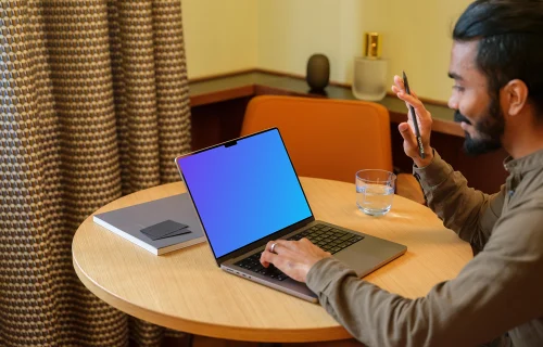 Man working on a MacBook Pro mockup in lounge