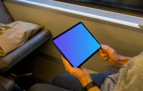 Passenger holding tablet mockup on the train