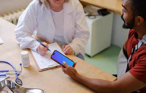 Patient holding an iPhone in doctor’s office
