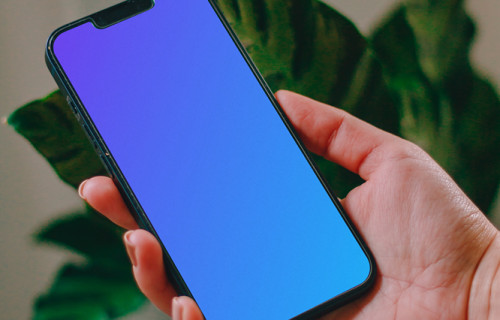 Person holding an iPhone 13 mockup