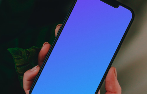 Person holding up an iPhone 13 mockup