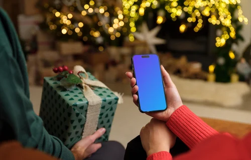 Person in red sweater holding a phone mockup